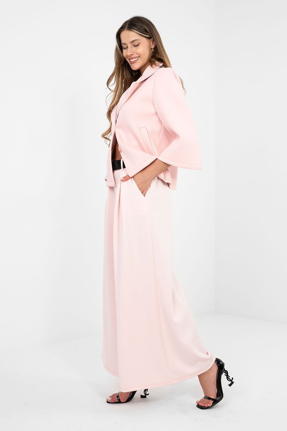 Woman wearing a light pink outfit on a white background