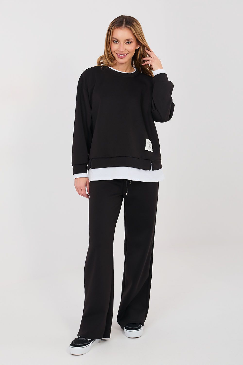 Woman wearing a black and white outfit on a white background