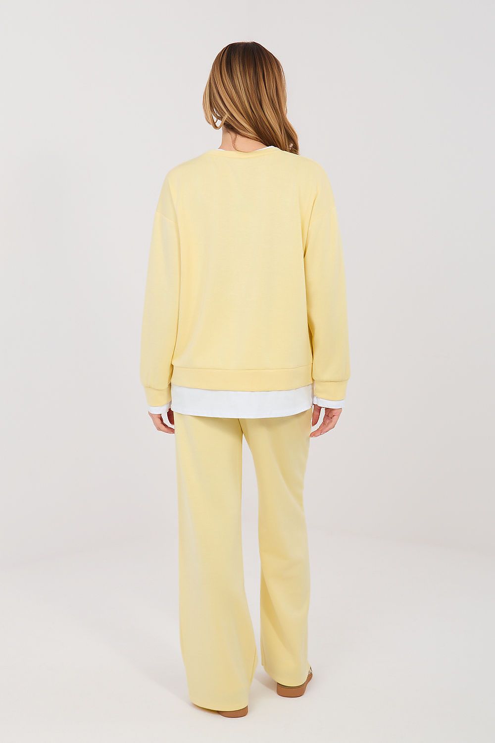Person wearing a yellow outfit on a white background