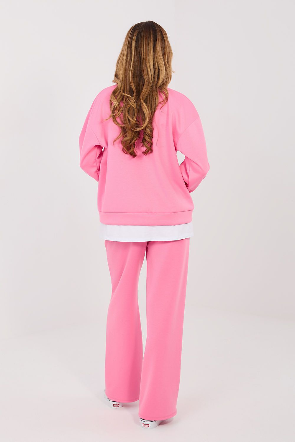 Person wearing a pink tracksuit on a white background