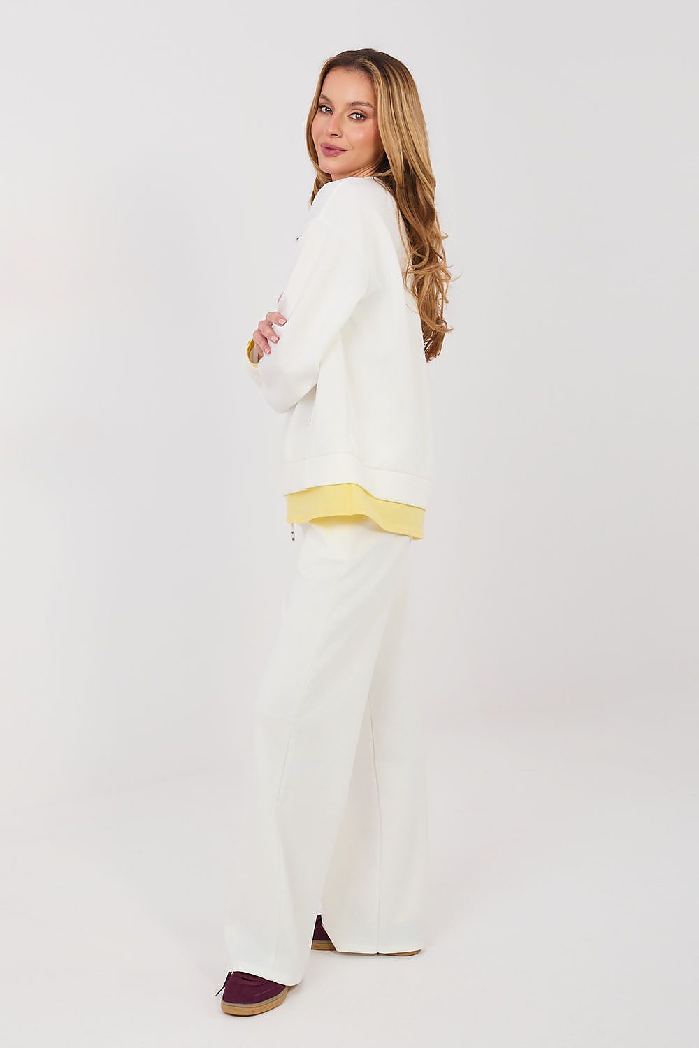 Woman wearing a white outfit with a yellow belt on a white background
