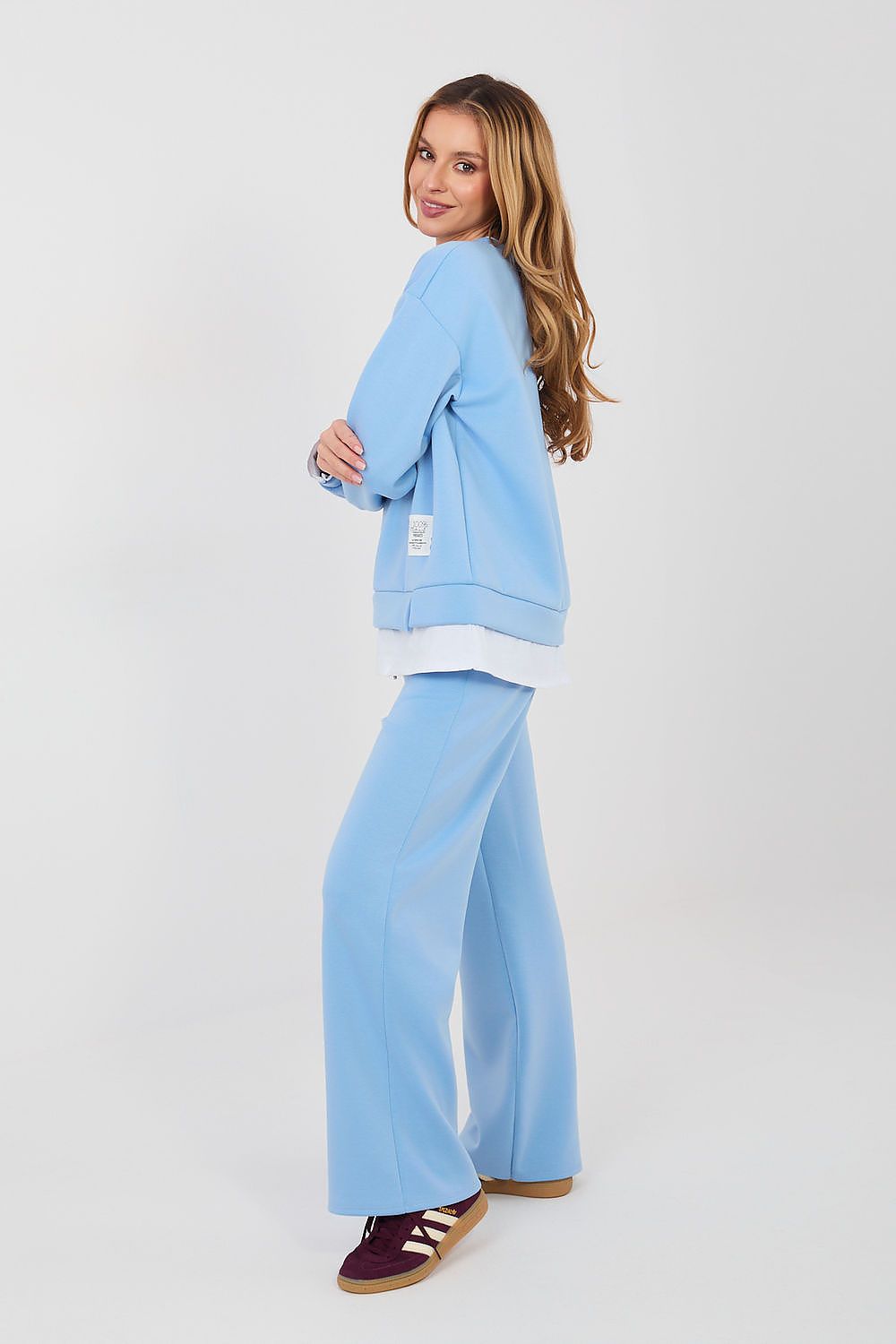 Woman wearing a light blue tracksuit on a white background