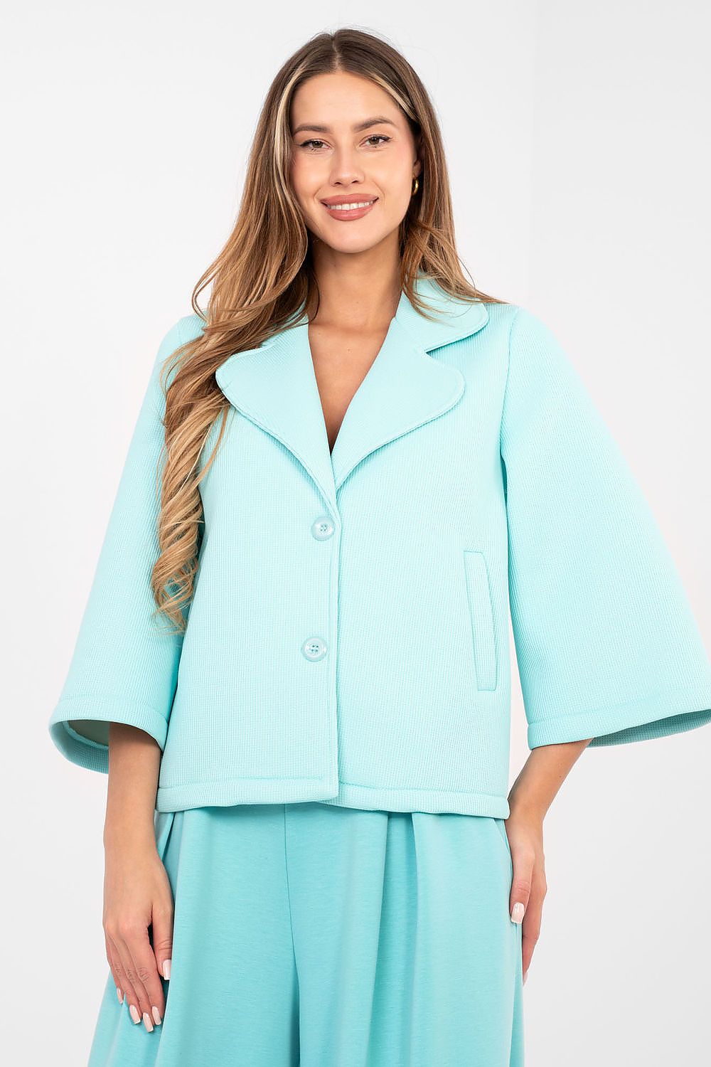 Woman wearing a light blue suit on a white background
