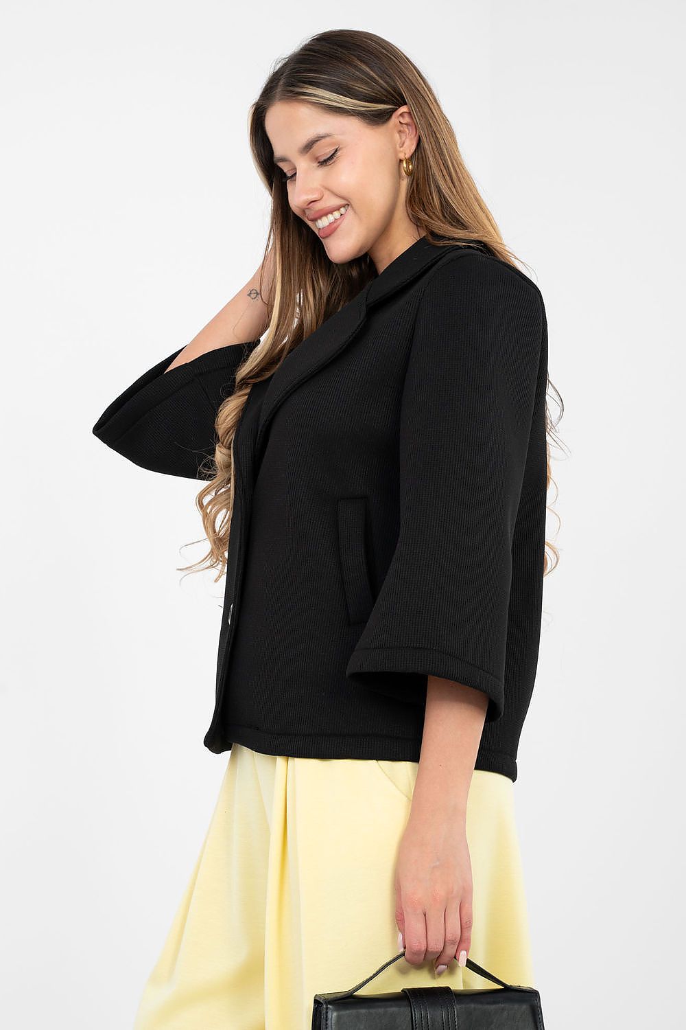 Woman wearing a black top and yellow skirt with a white background