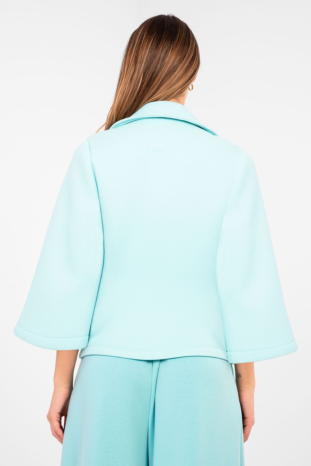 Person wearing a light blue outfit on a white background