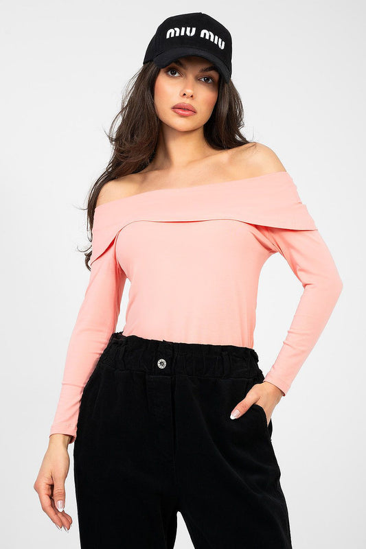 Woman wearing a pink off-shoulder top and black cap with 'MIU MIU' branding on a white background