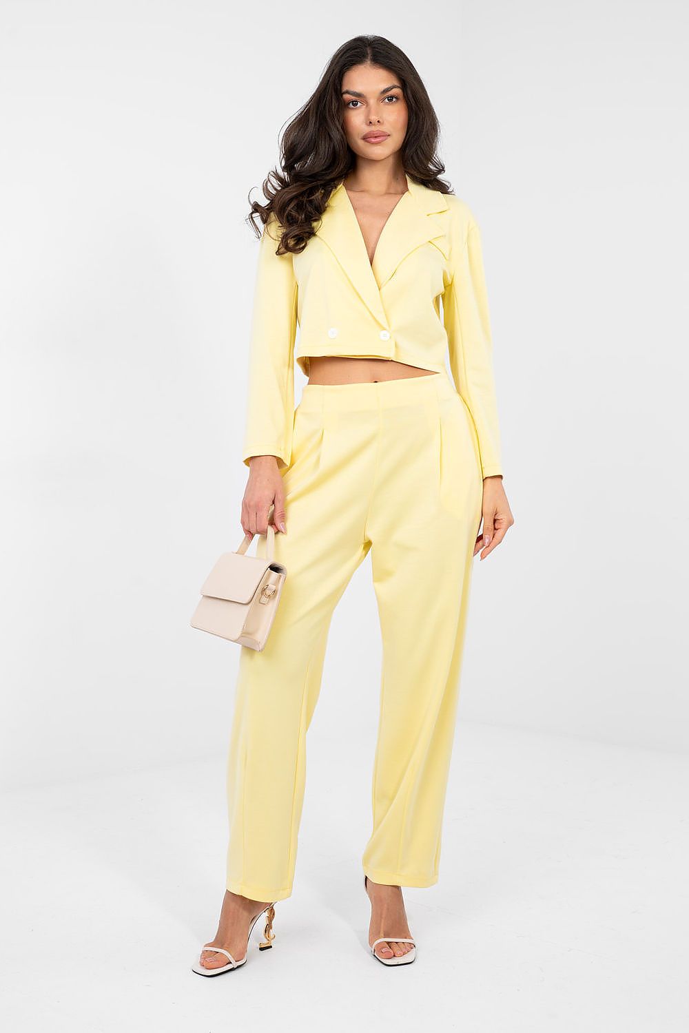 Woman wearing a yellow suit with a white background