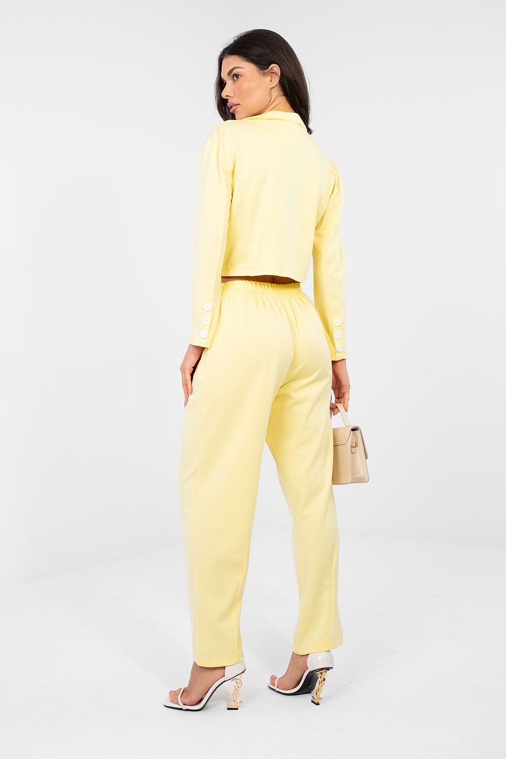 Woman wearing a yellow suit with a white background