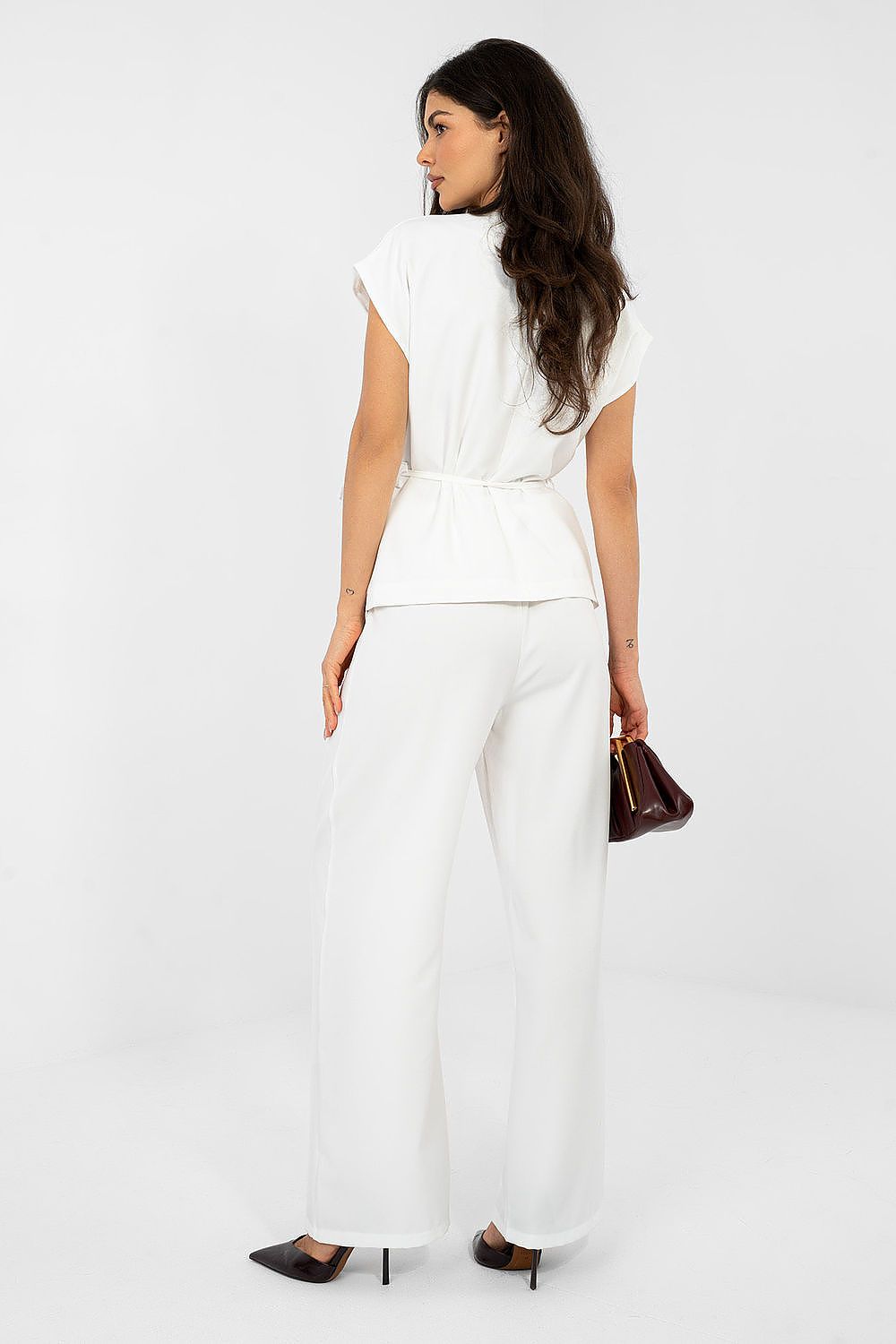 Woman wearing a white outfit with a plain background