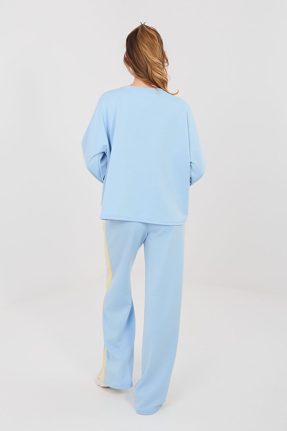 Person wearing a light blue outfit on a white background