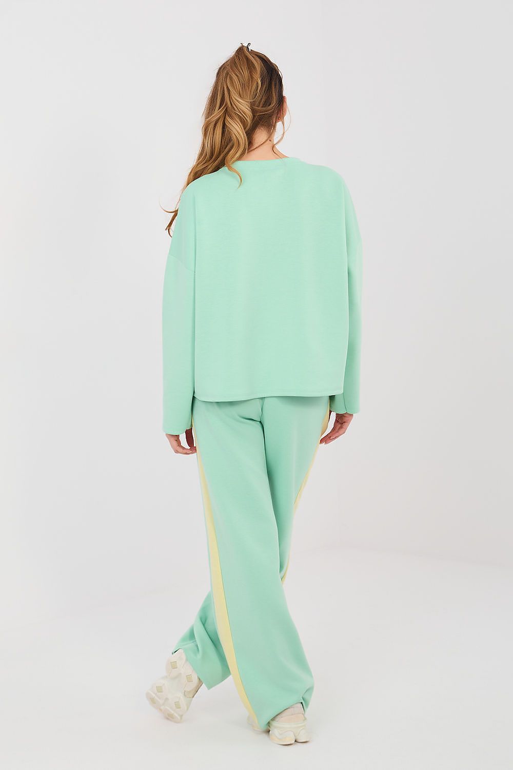 Person wearing a mint green outfit with a white background