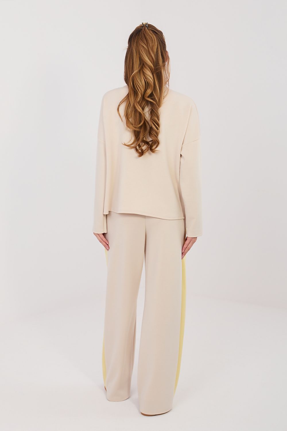 Woman wearing a beige suit with a white background