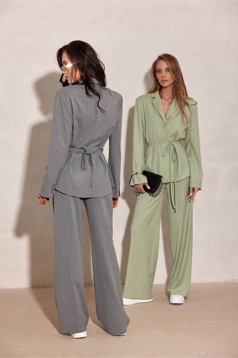 Two women wearing wide-leg striped trousers with a tailored fit
