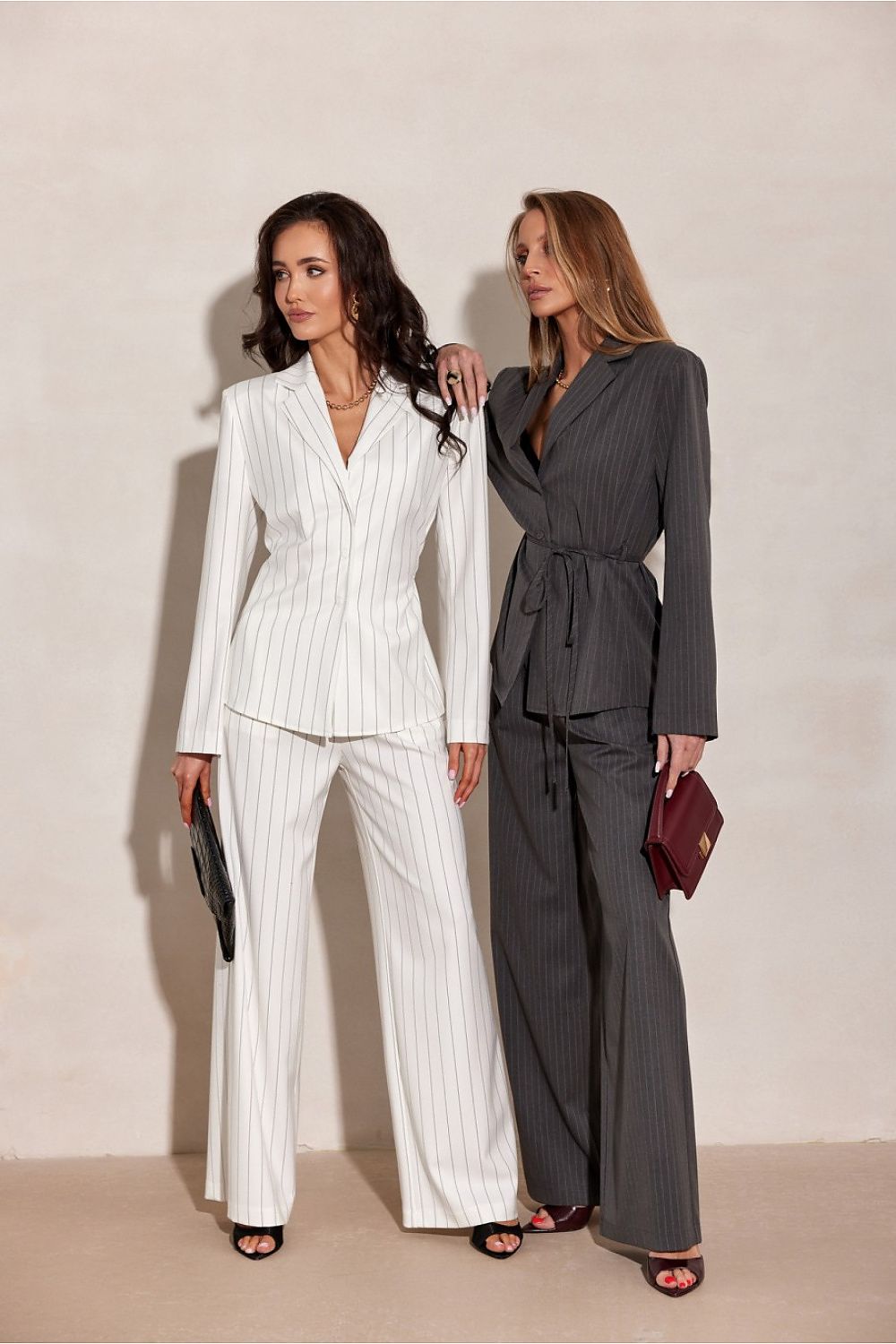 Two women wearing beige, grey suit