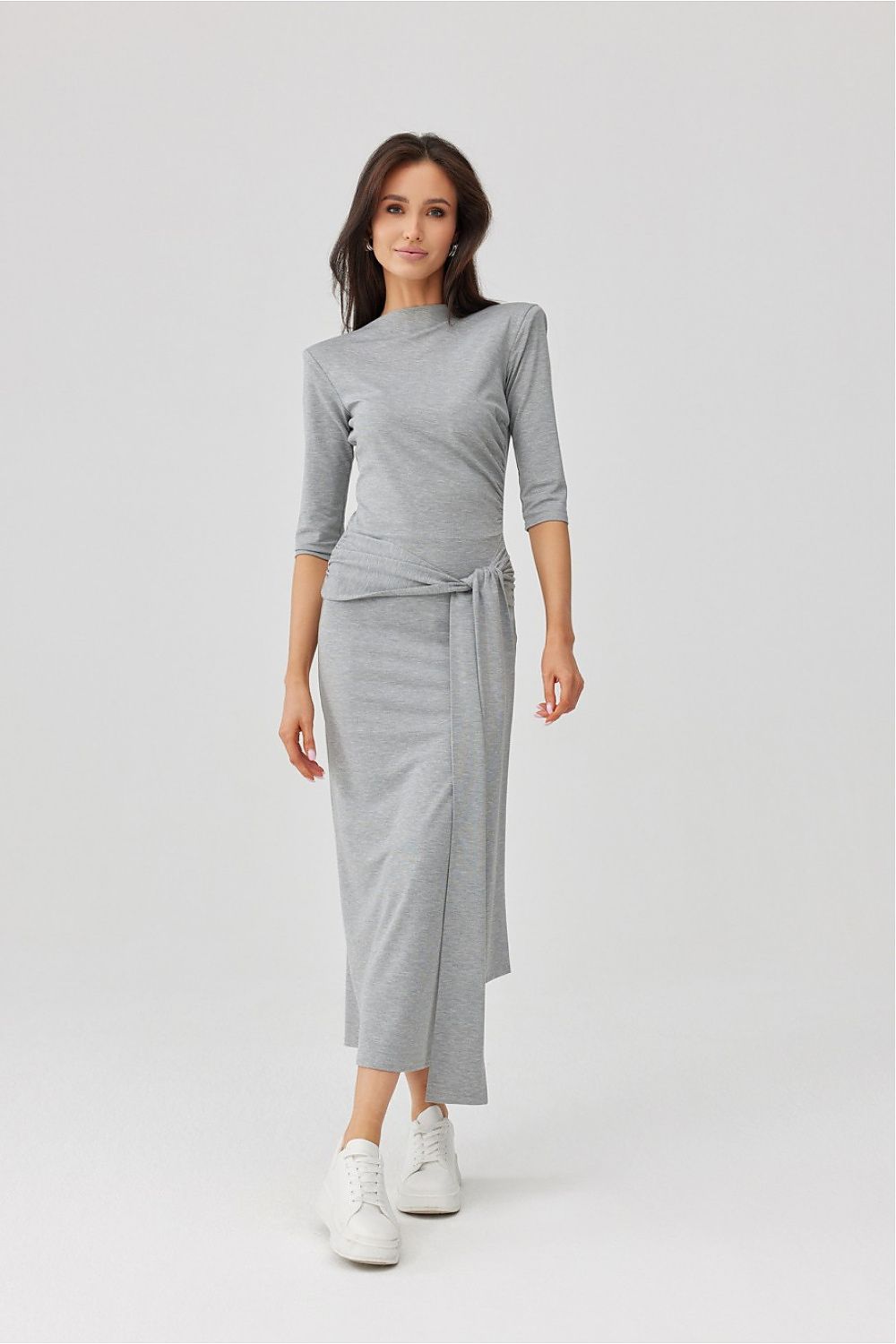 Woman wearing a gray outfit with a white background