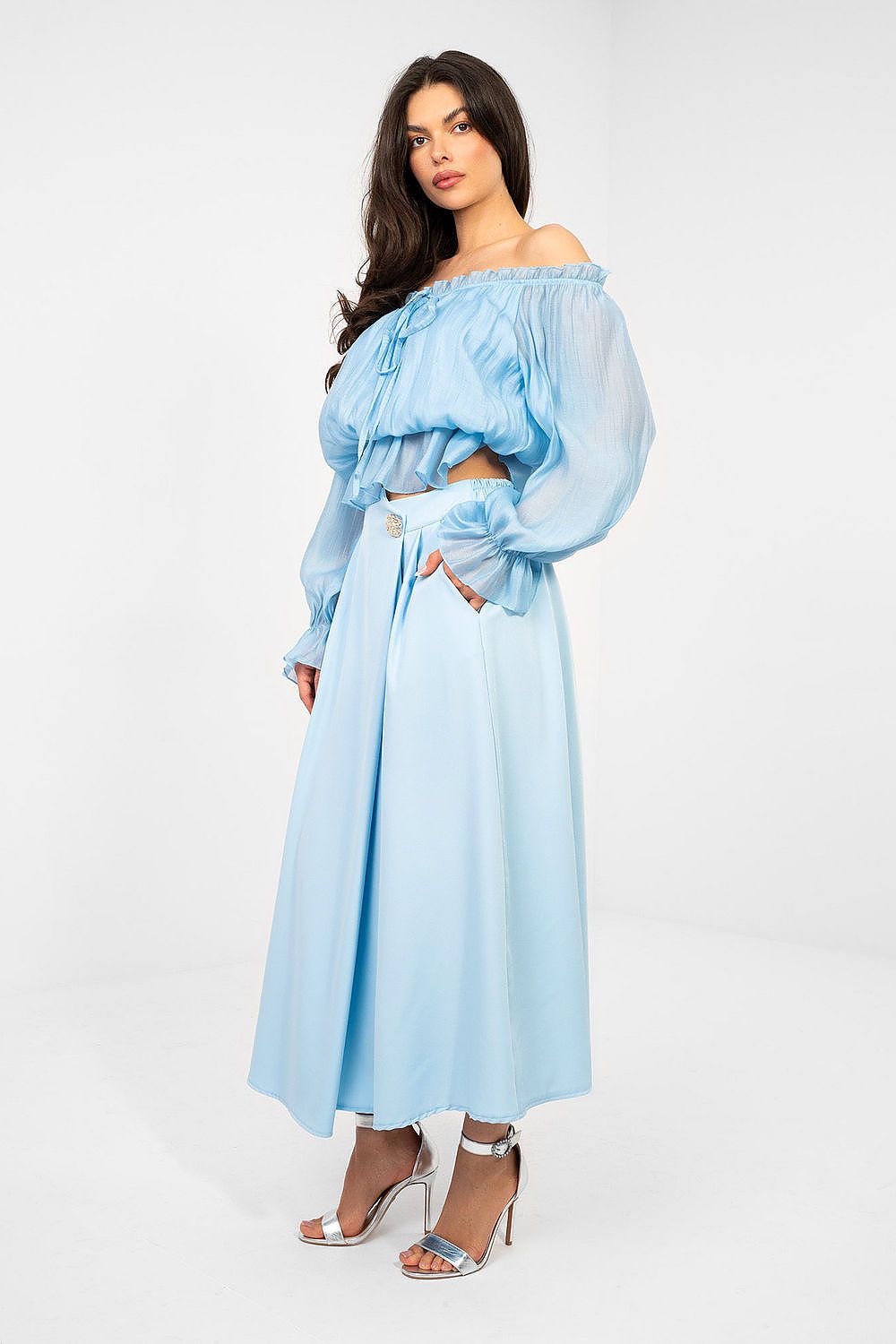 Woman wearing a light blue off-shoulder top and skirt set on a white background