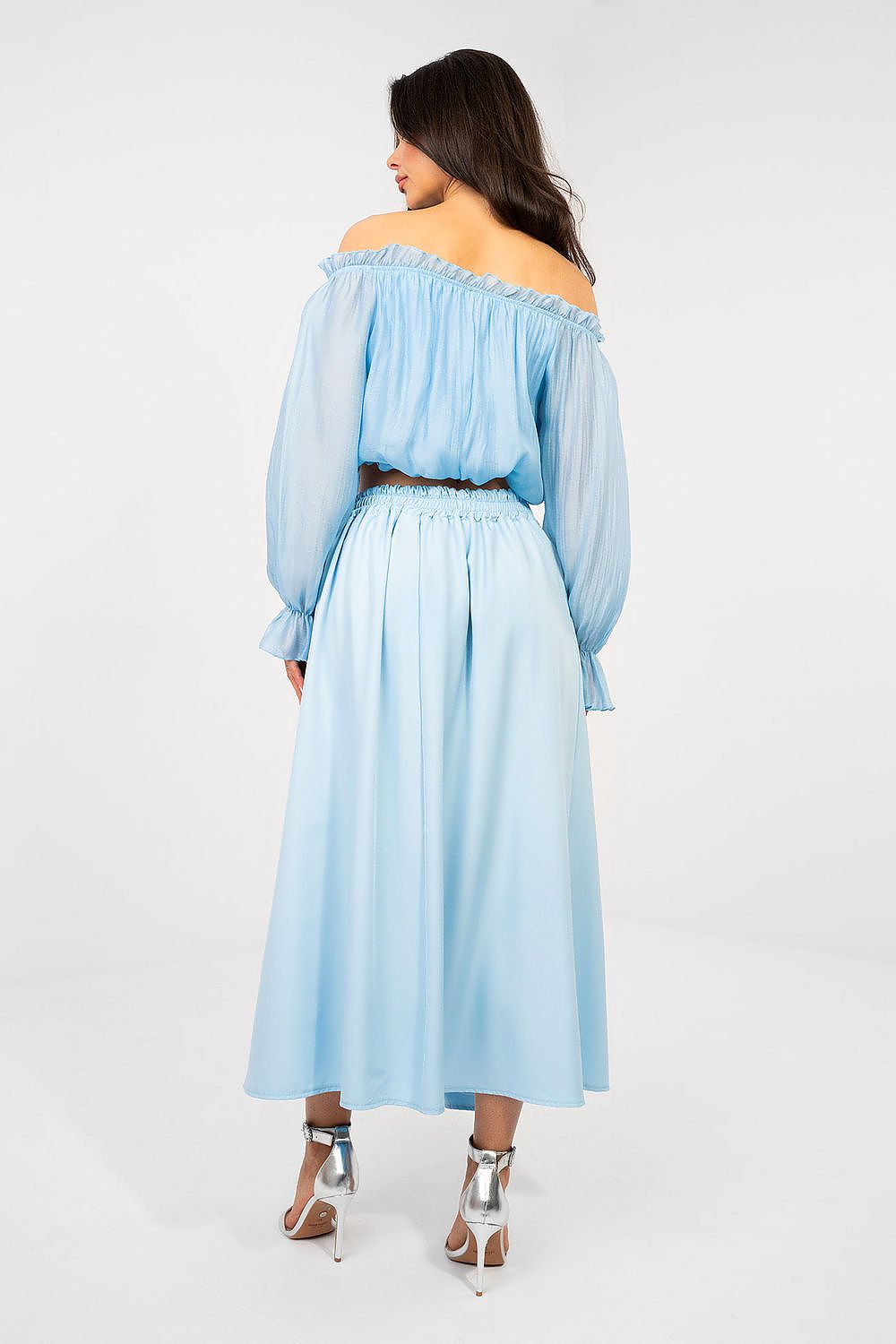 Woman wearing a light blue off-shoulder dress on a white background