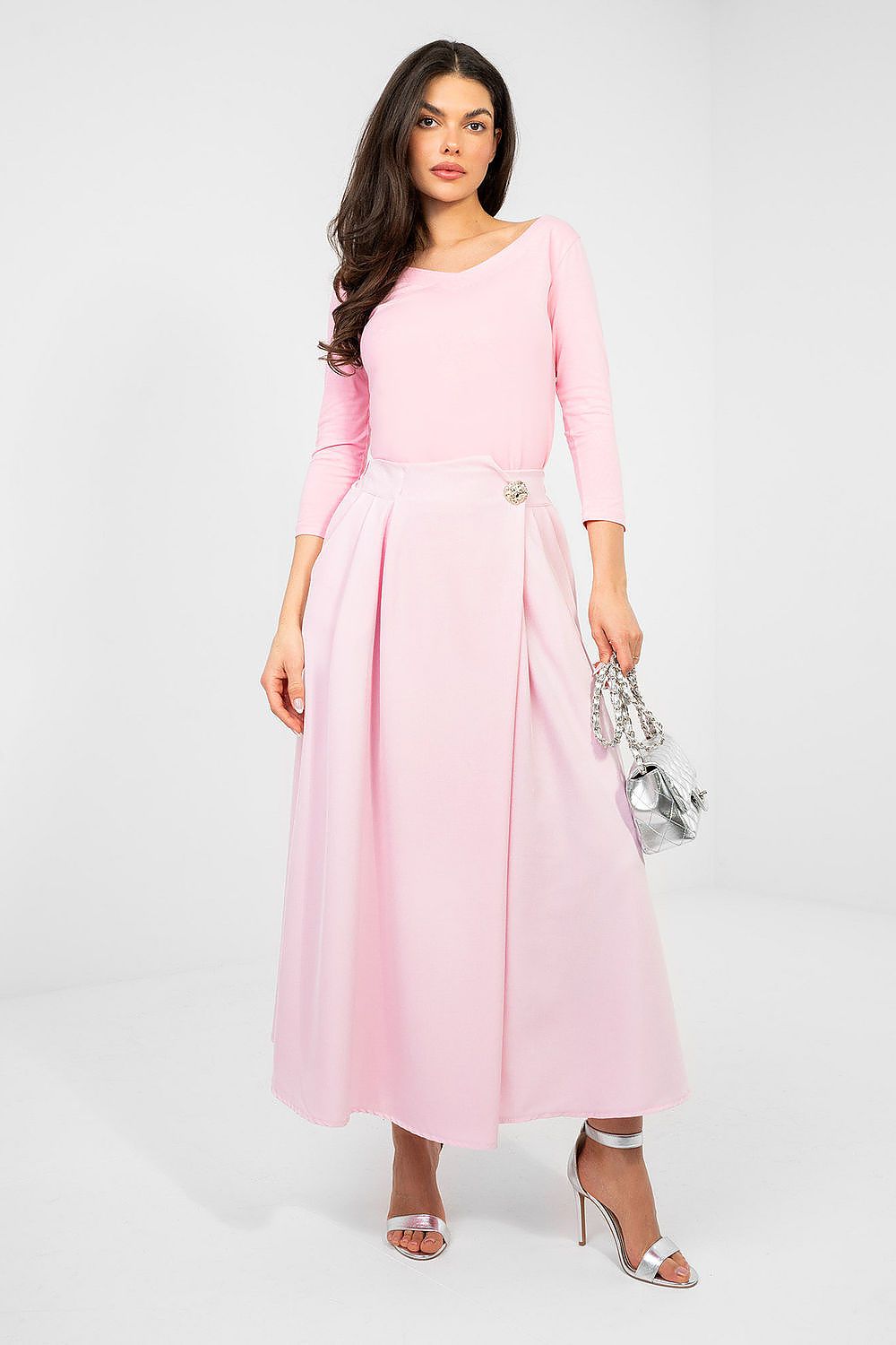 Woman wearing a pink dress with a plain background