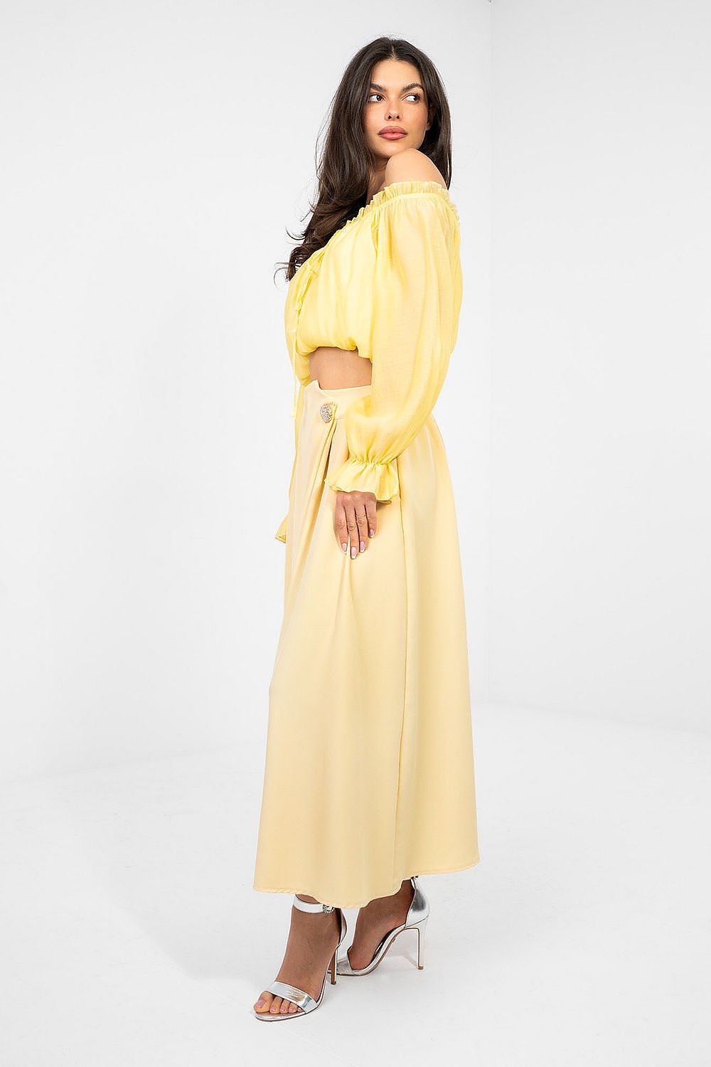 Woman wearing a yellow dress with long sleeves on a white background