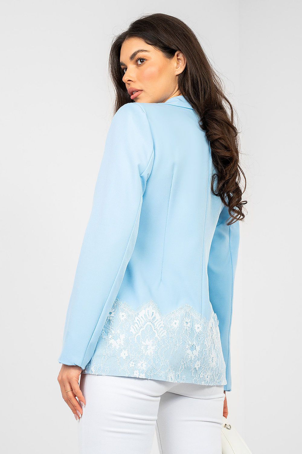 Woman wearing a light blue blazer with floral details on a white background