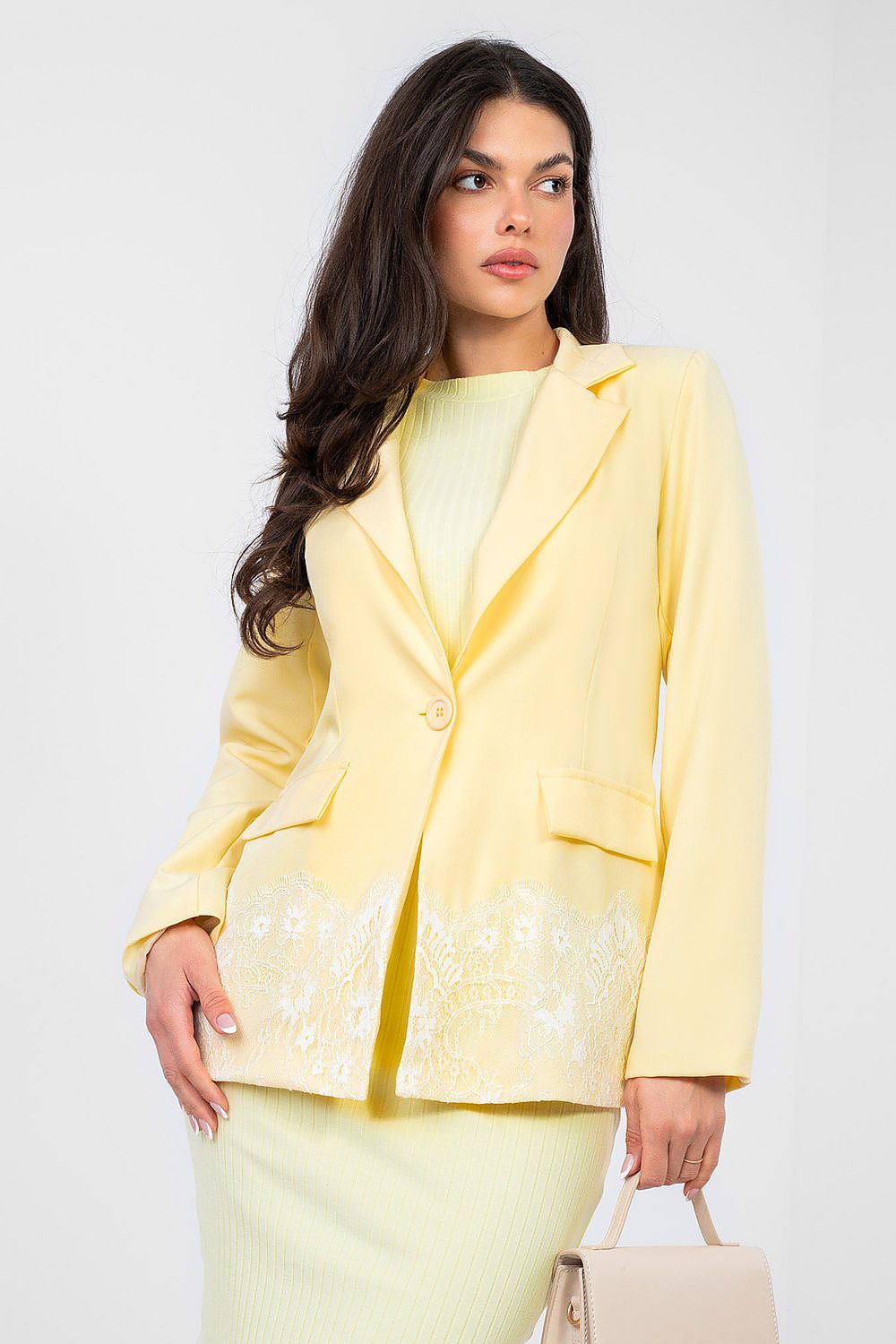 Woman wearing a yellow blazer and skirt set on a white background