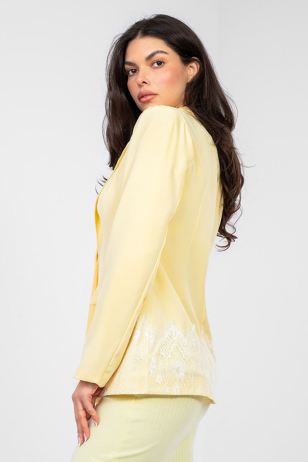Woman wearing a light yellow outfit with a plain background
