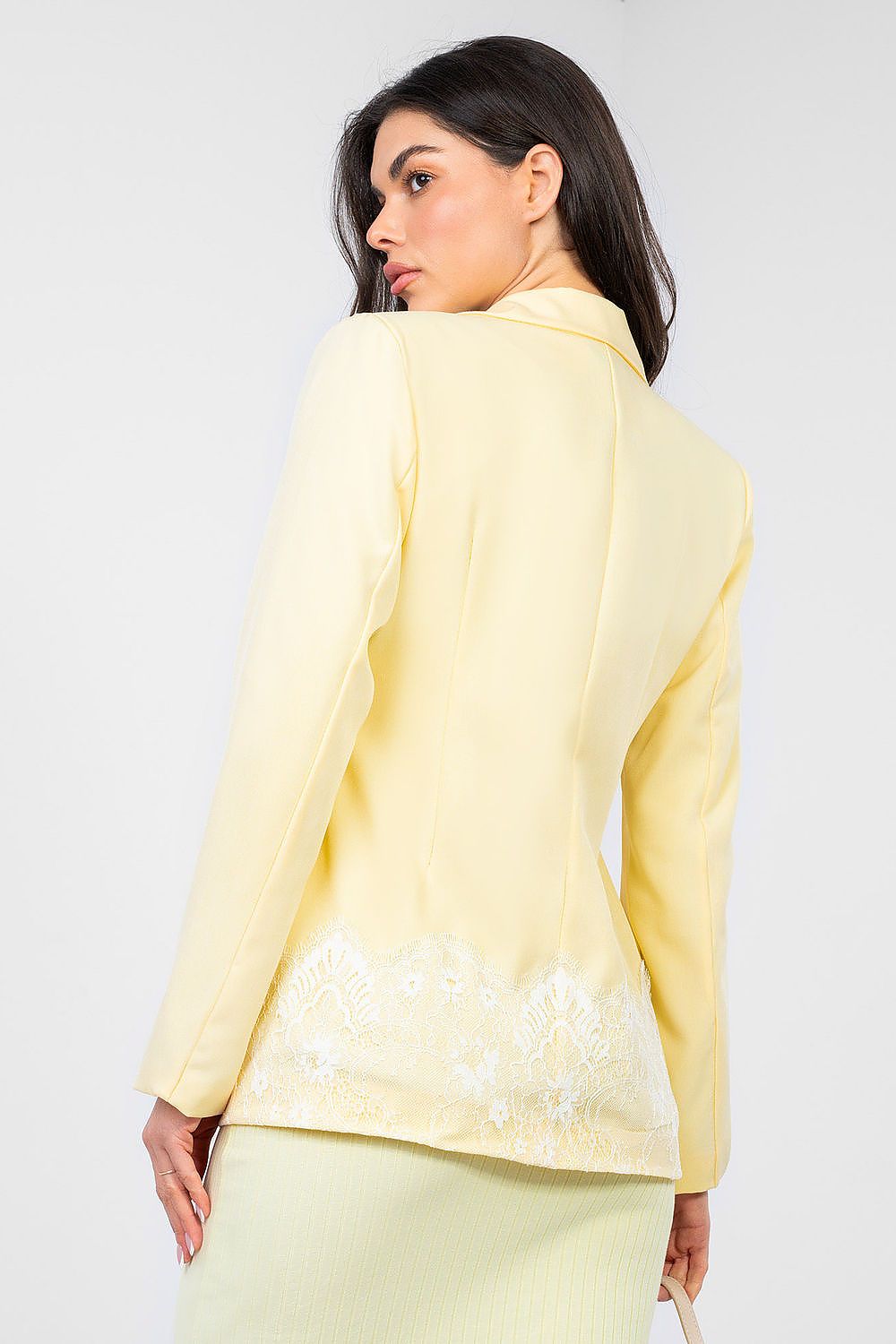 Woman wearing a light yellow outfit with a plain background