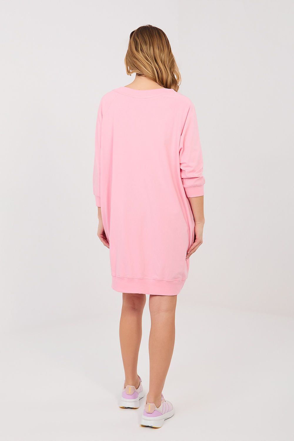 Person wearing a pink dress on a white background