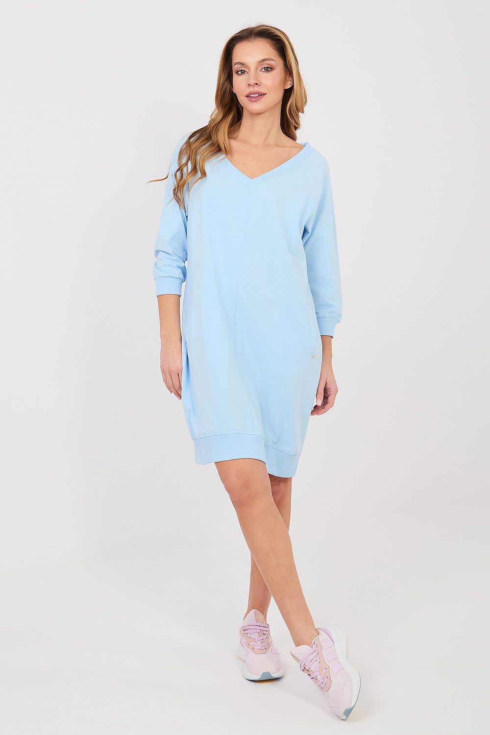 Woman wearing a light blue dress on a white background