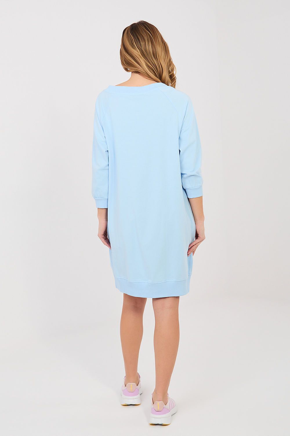 Woman wearing a light blue dress on a white background