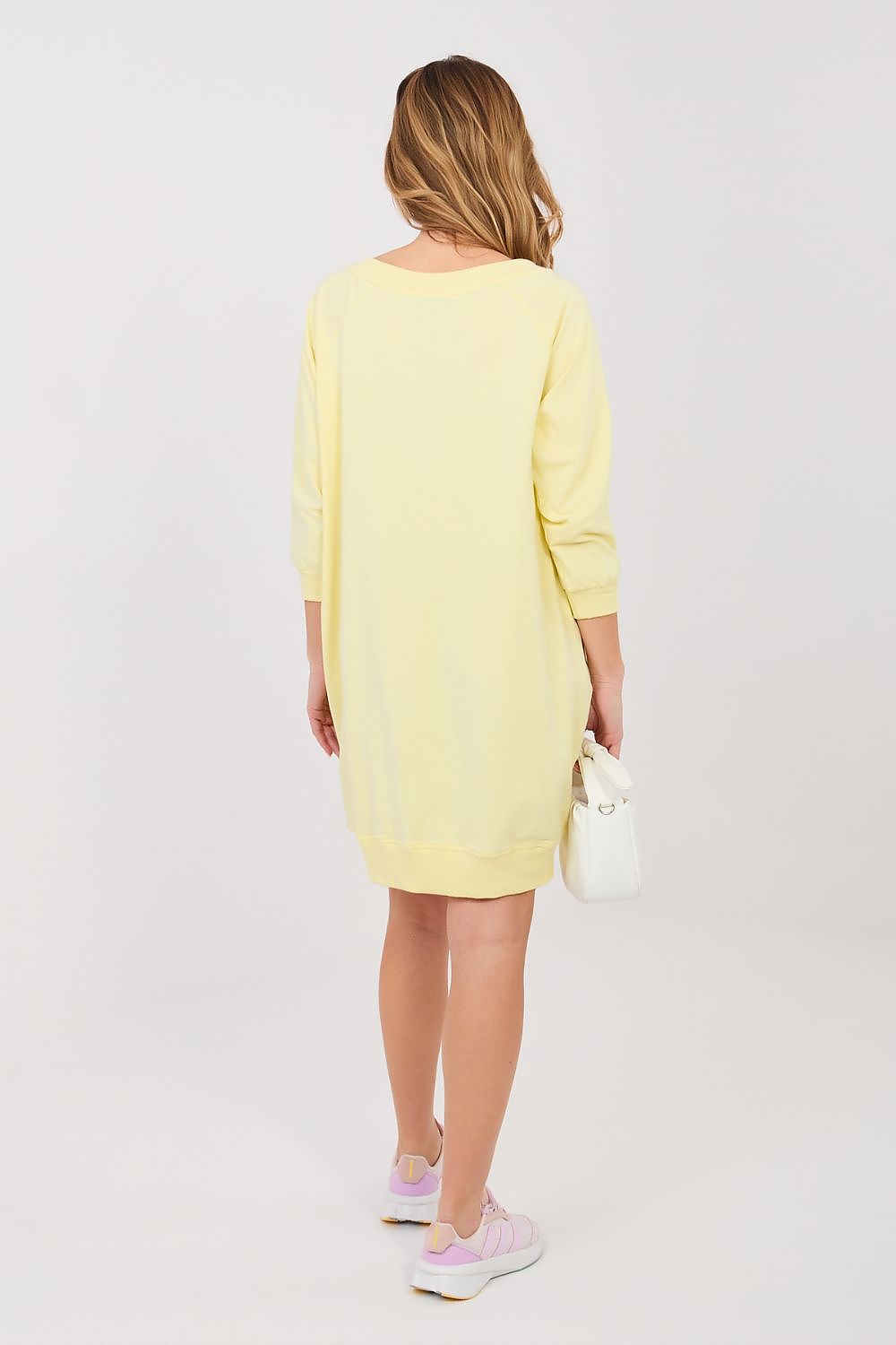 Woman wearing a yellow dress on a white background