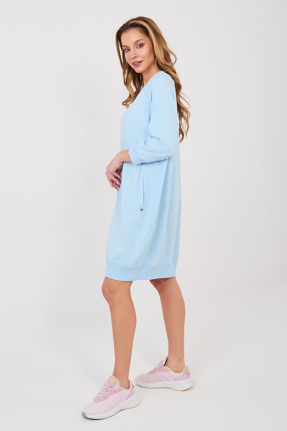 Woman wearing a light blue dress on a white background