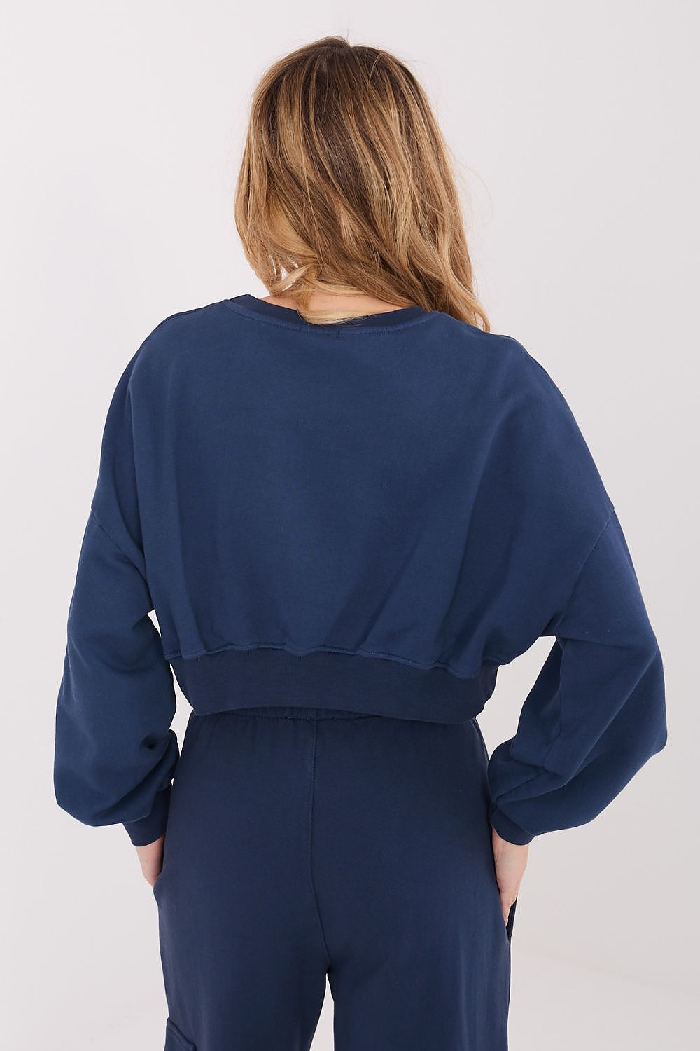 Person wearing a navy blue outfit on a white background