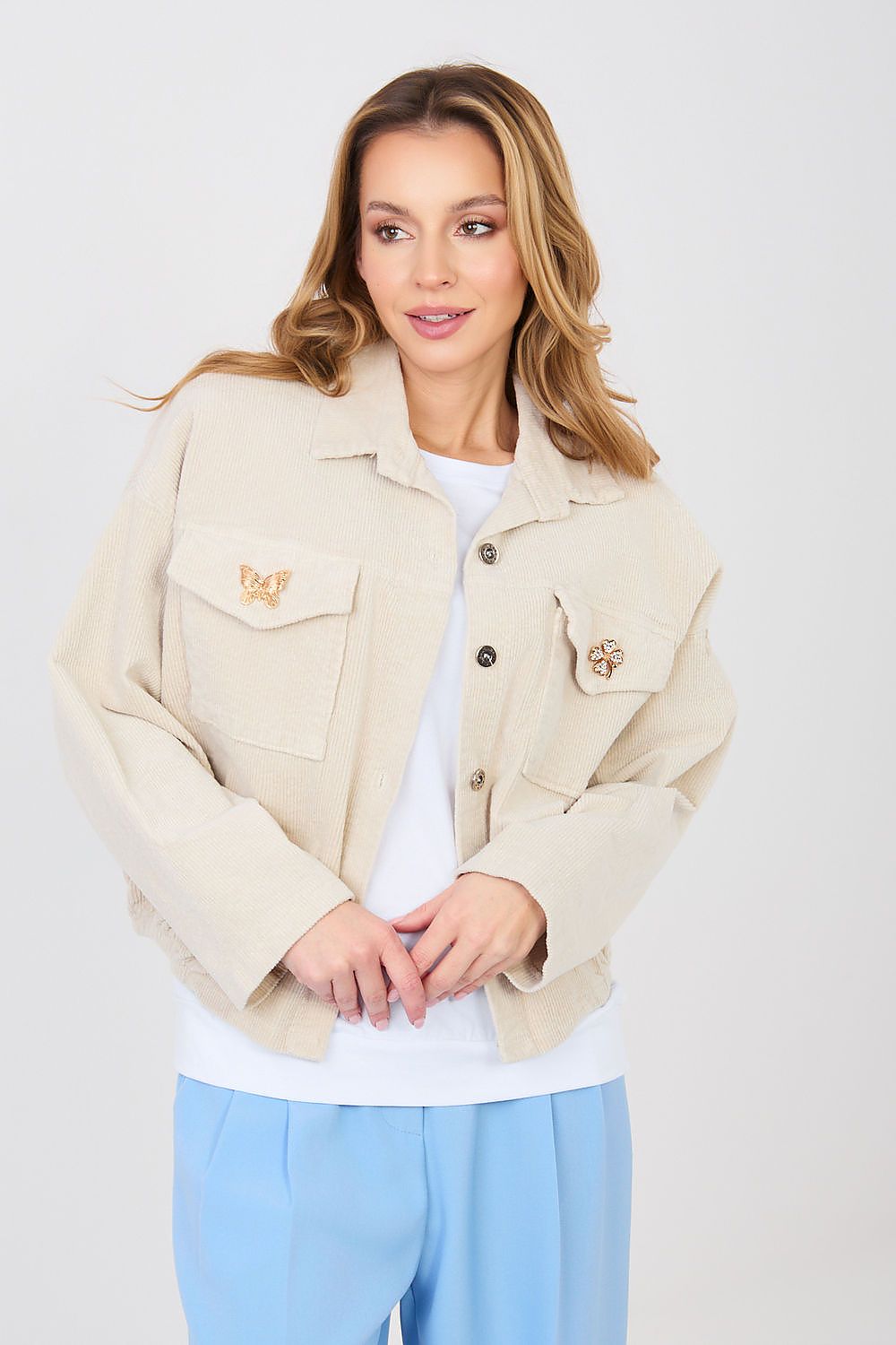 Woman wearing a beige jacket with a brand logo on a white background
