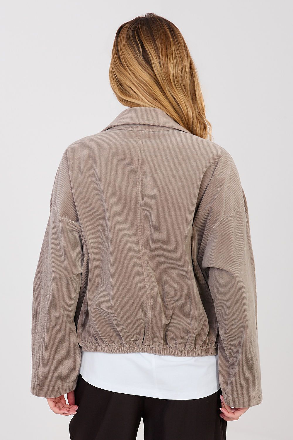 Person wearing a brown corduroy jacket on a white background