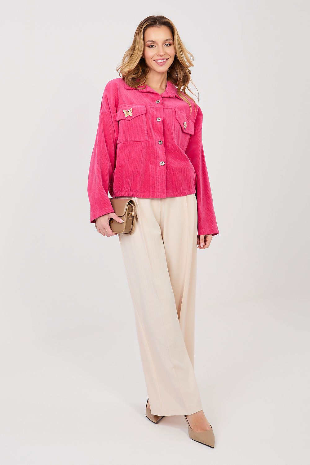 Woman wearing a pink jacket and beige pants on a white background