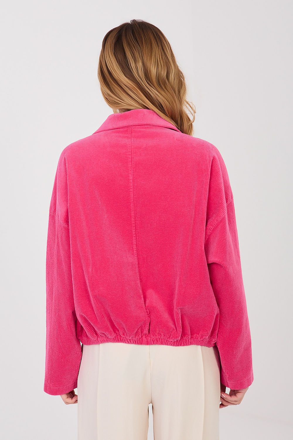 Person wearing a bright pink jacket on a white background
