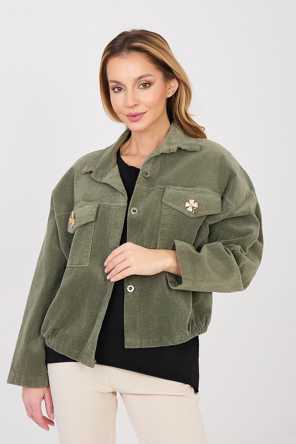 Woman wearing an olive green jacket with floral details on a white background
