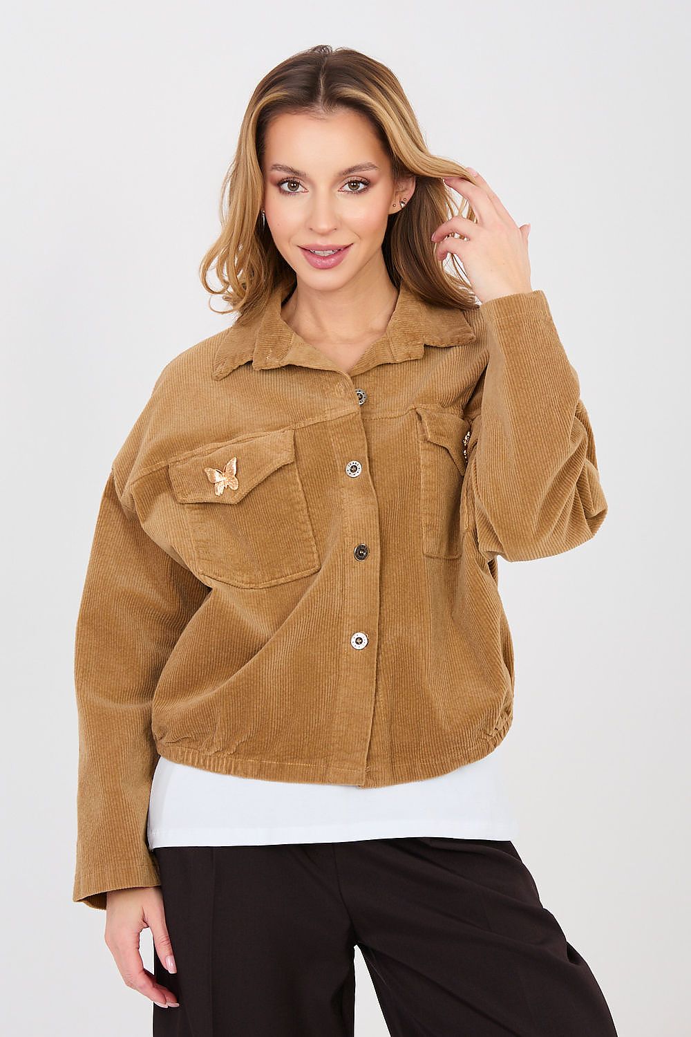 Woman wearing a brown corduroy jacket on a white background