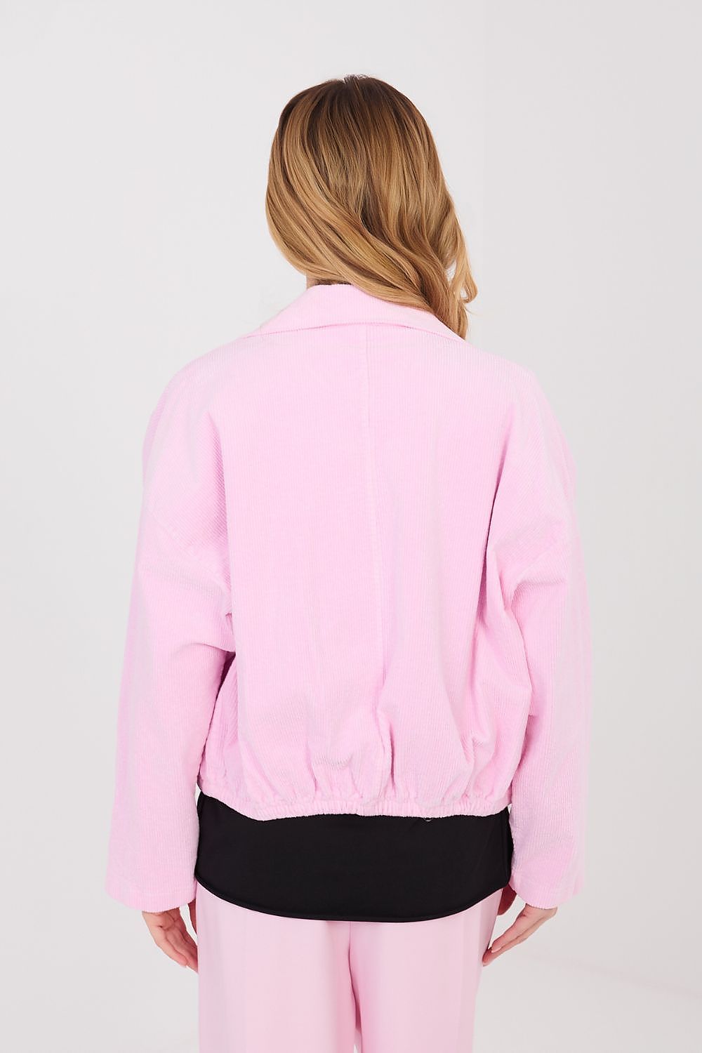 Person wearing a pink jacket and pants on a white background