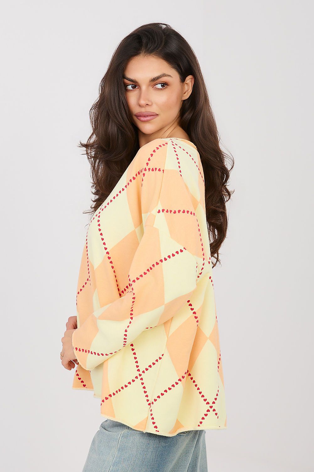 Woman wearing a patterned top with a plain background