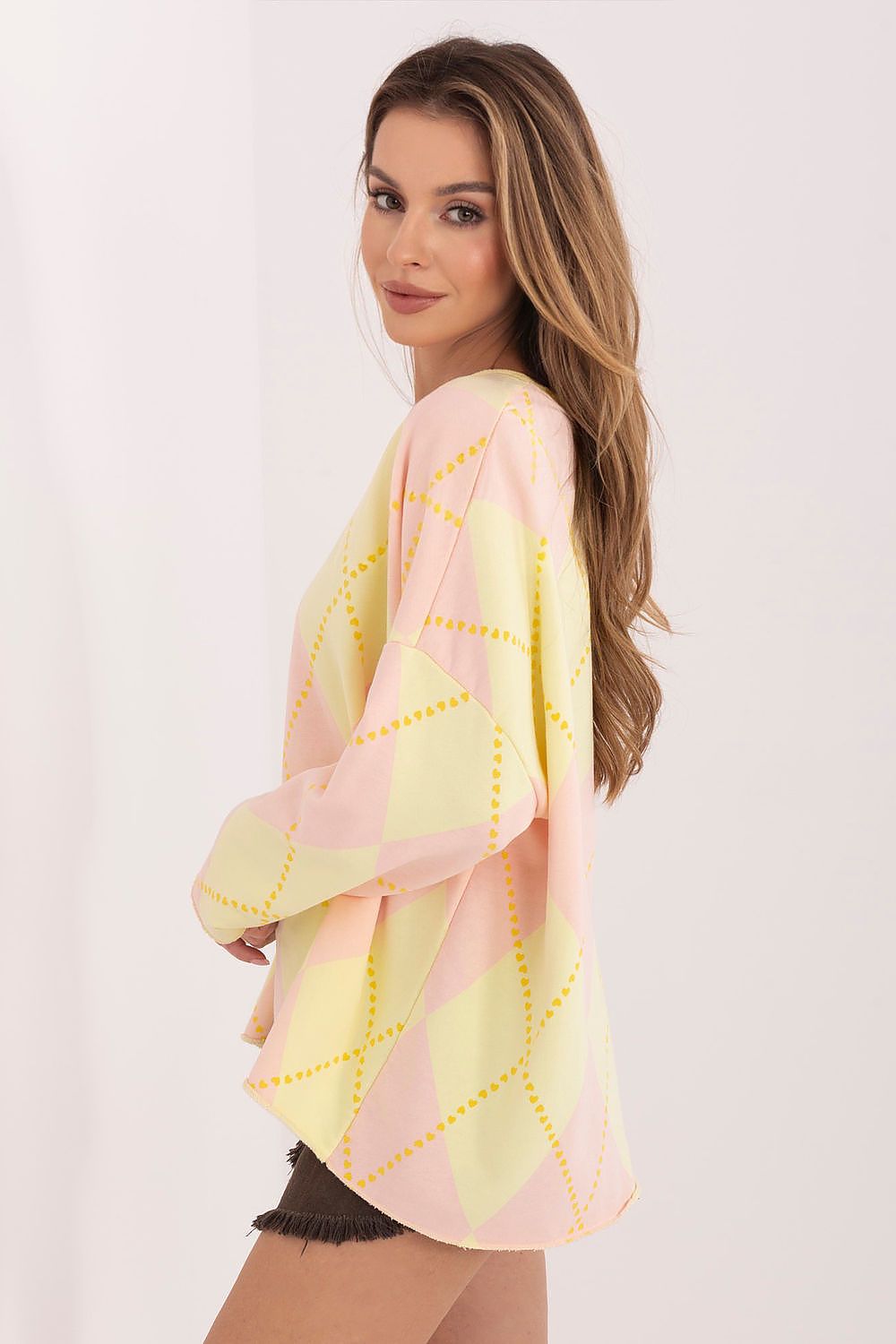 Woman wearing a pink and yellow kimono-style garment on a white background