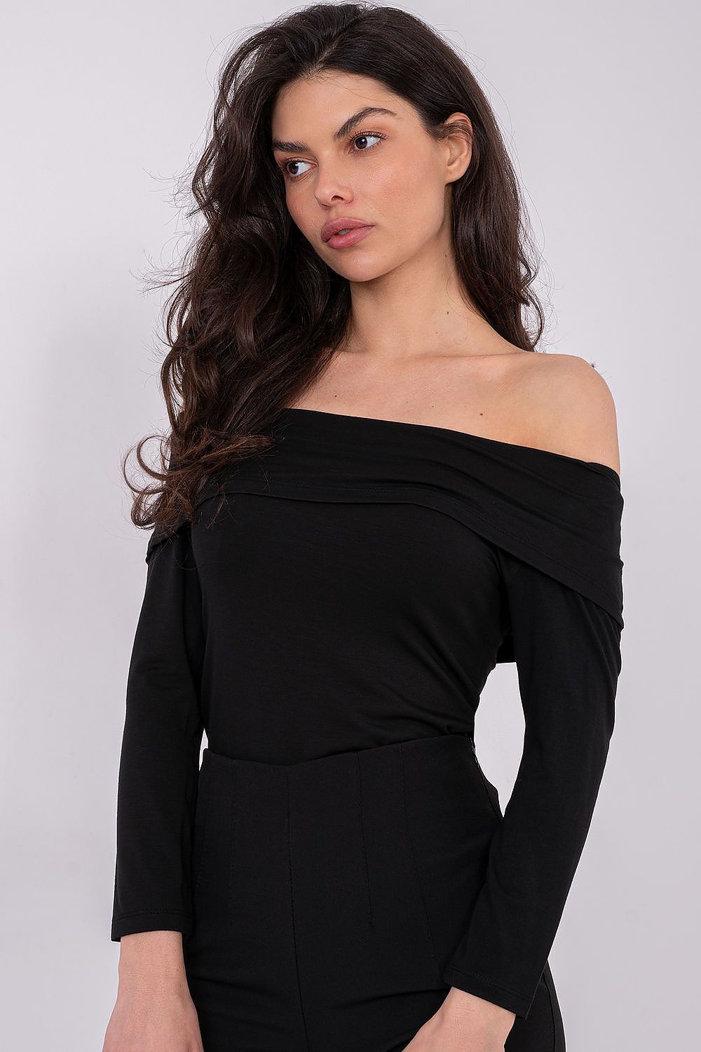 Woman wearing a black off-shoulder dress against a white background