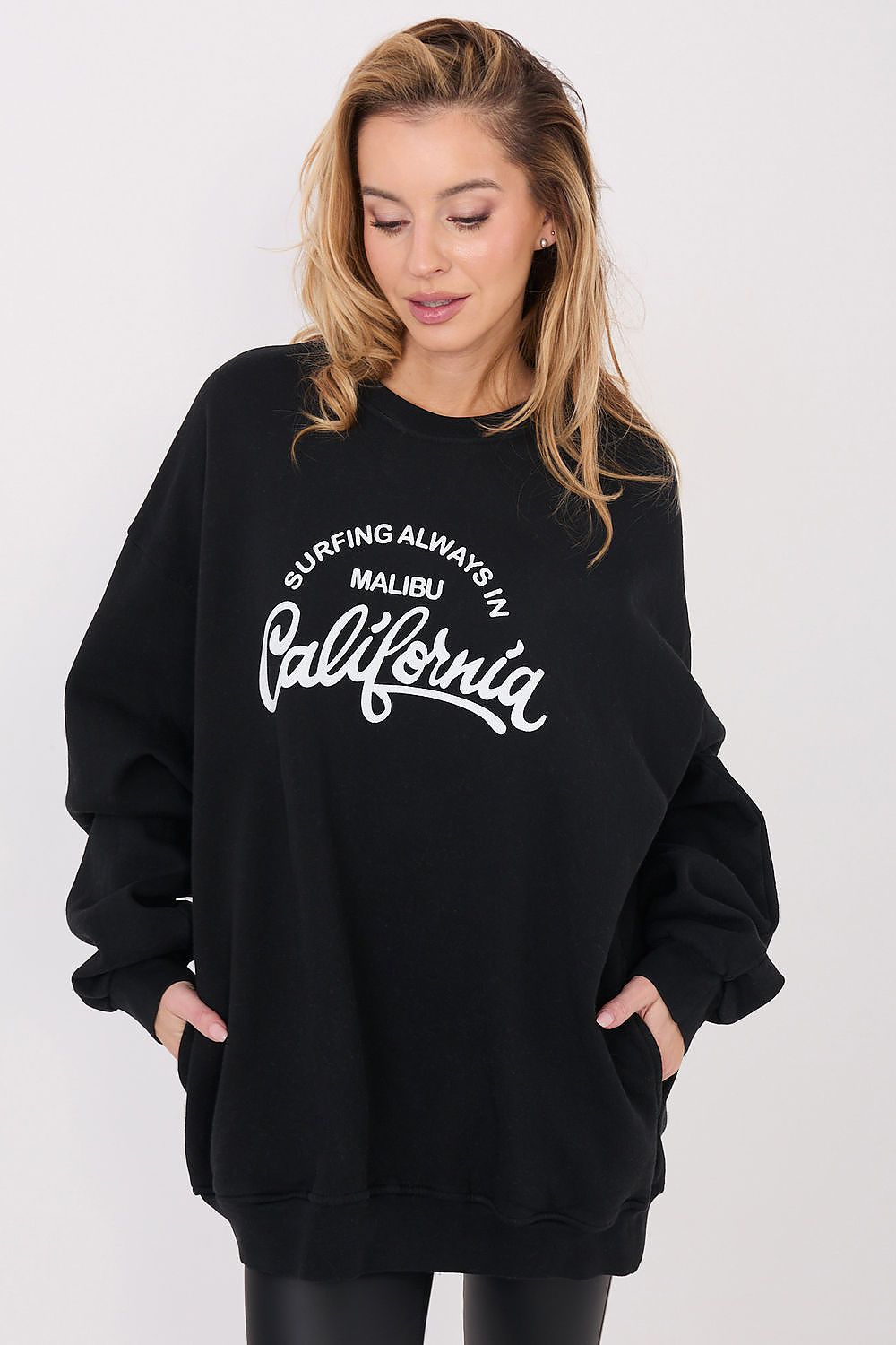 Woman wearing a black sweatshirt with white text on a white background