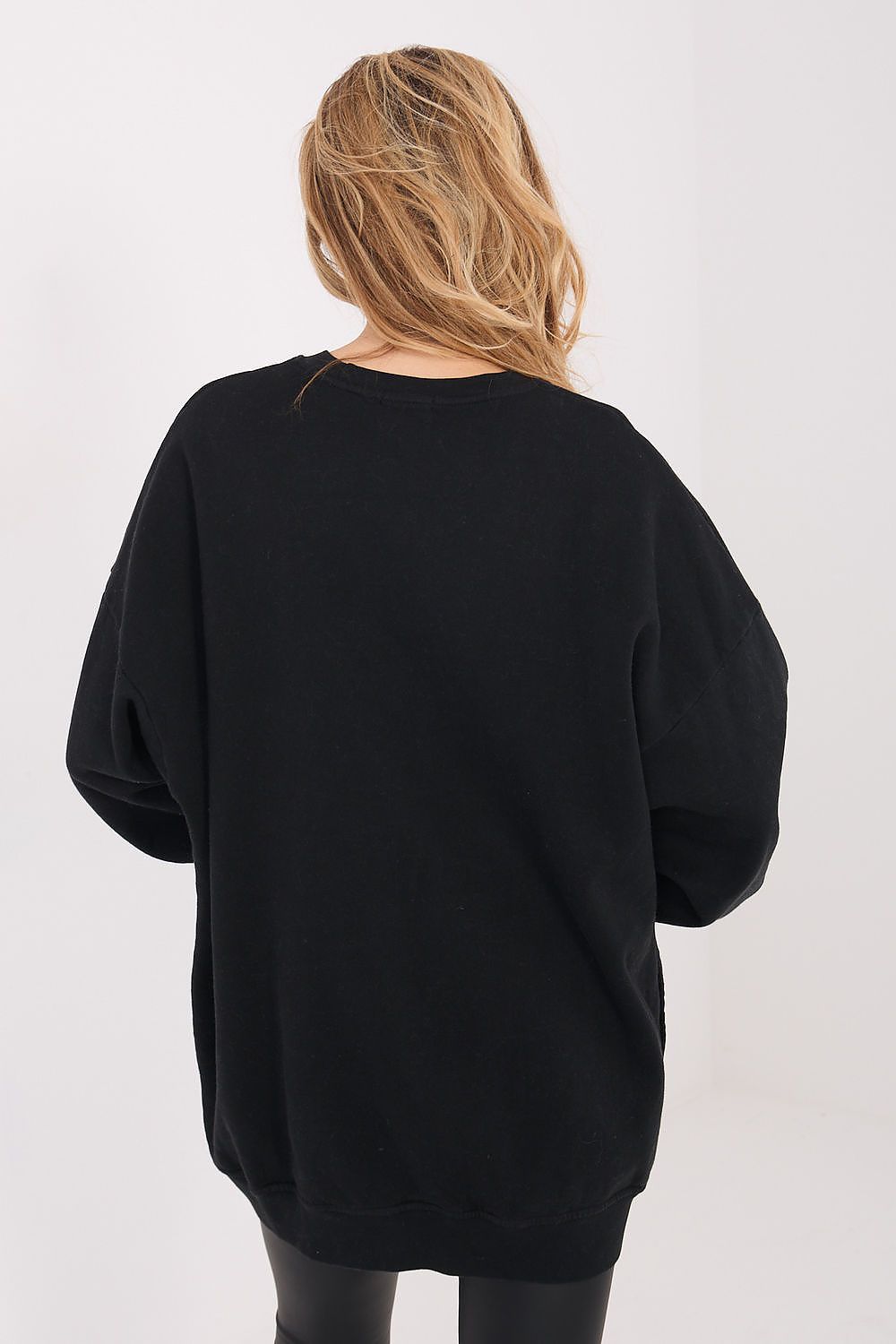 Person wearing a black oversized sweater on a white background