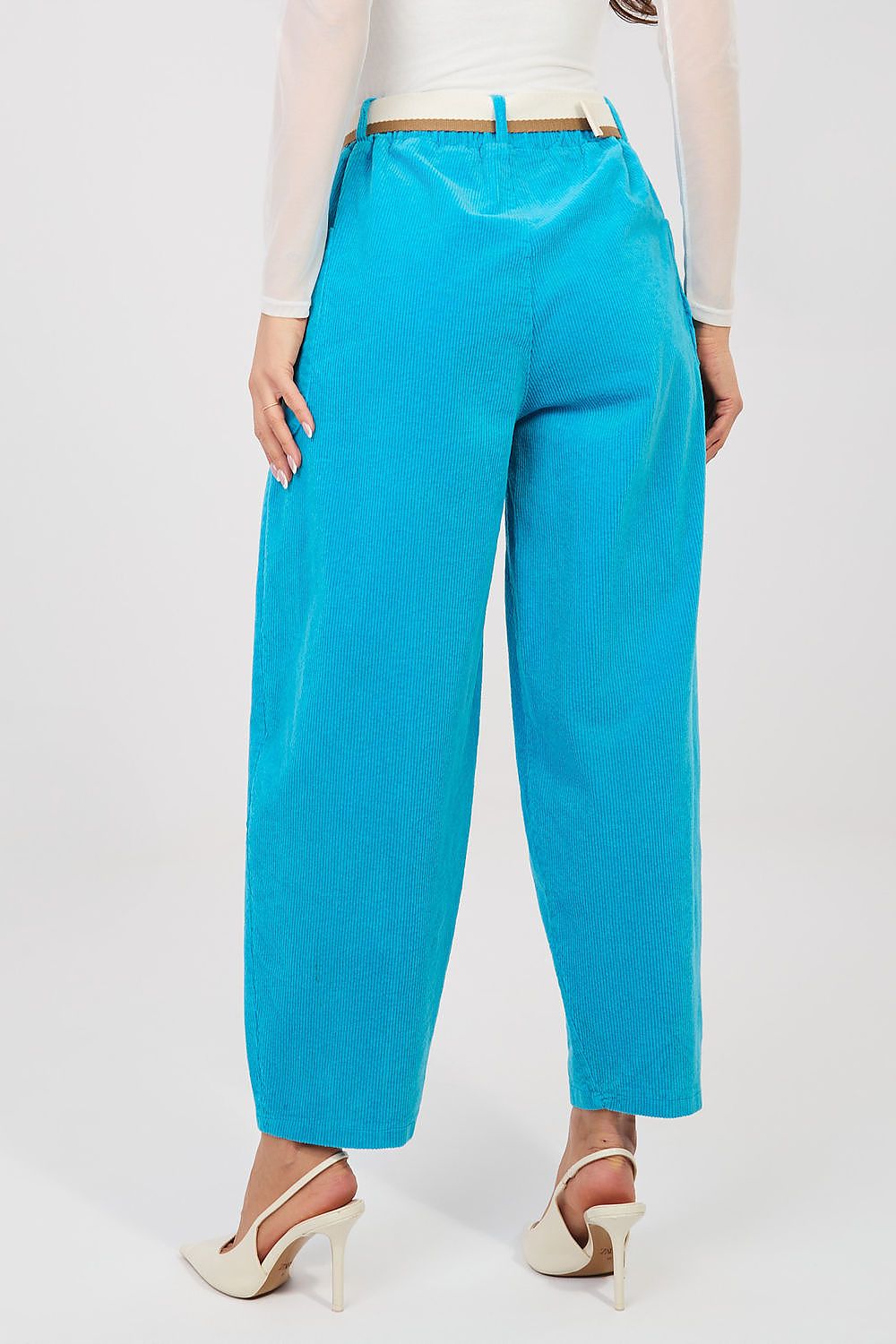 Person wearing bright blue pants on a white background