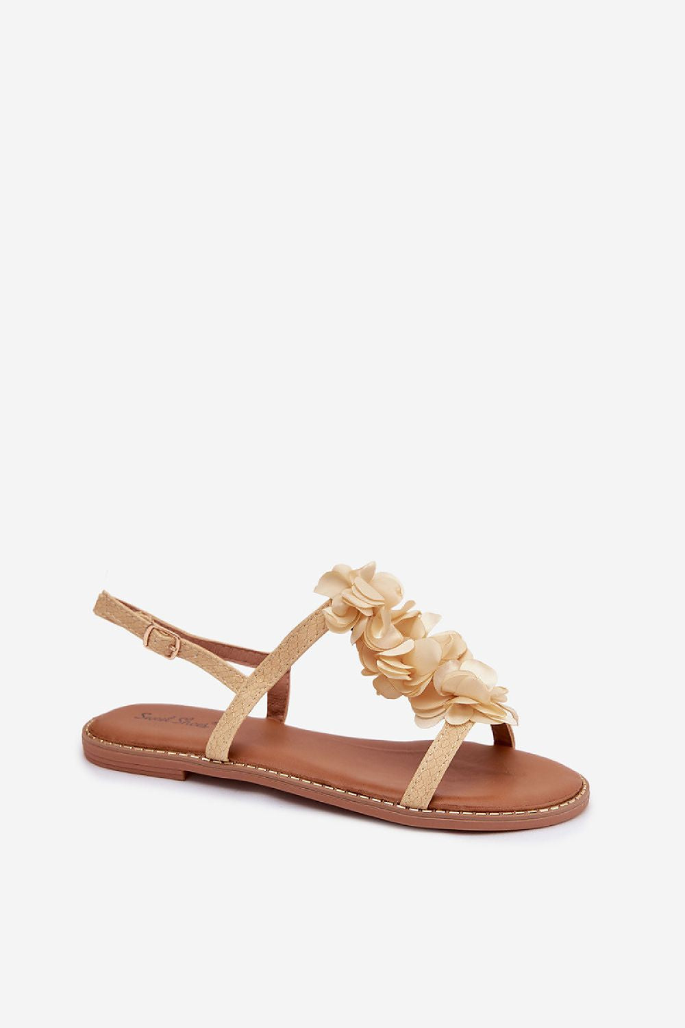 Beige sandal with floral details on a white background