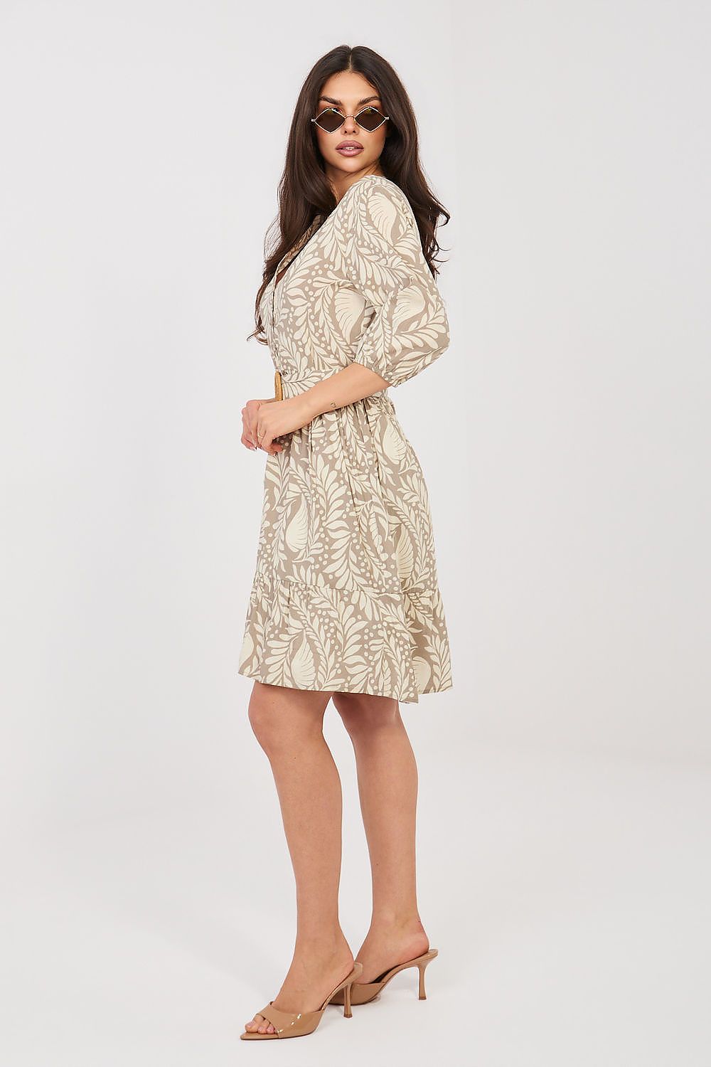 Woman wearing a beige floral dress on a white background