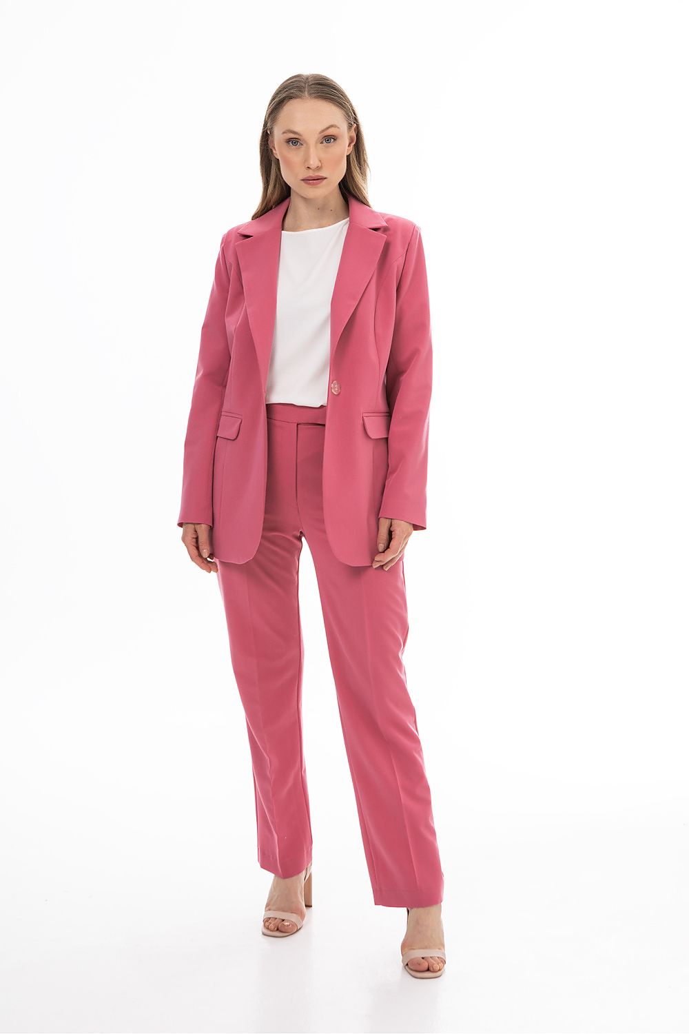 Woman wearing a pink suit with a white shirt on a white background