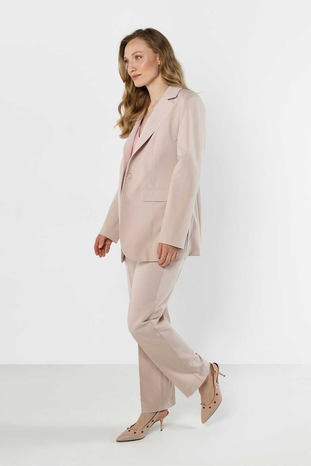 Woman wearing a beige suit on a white background